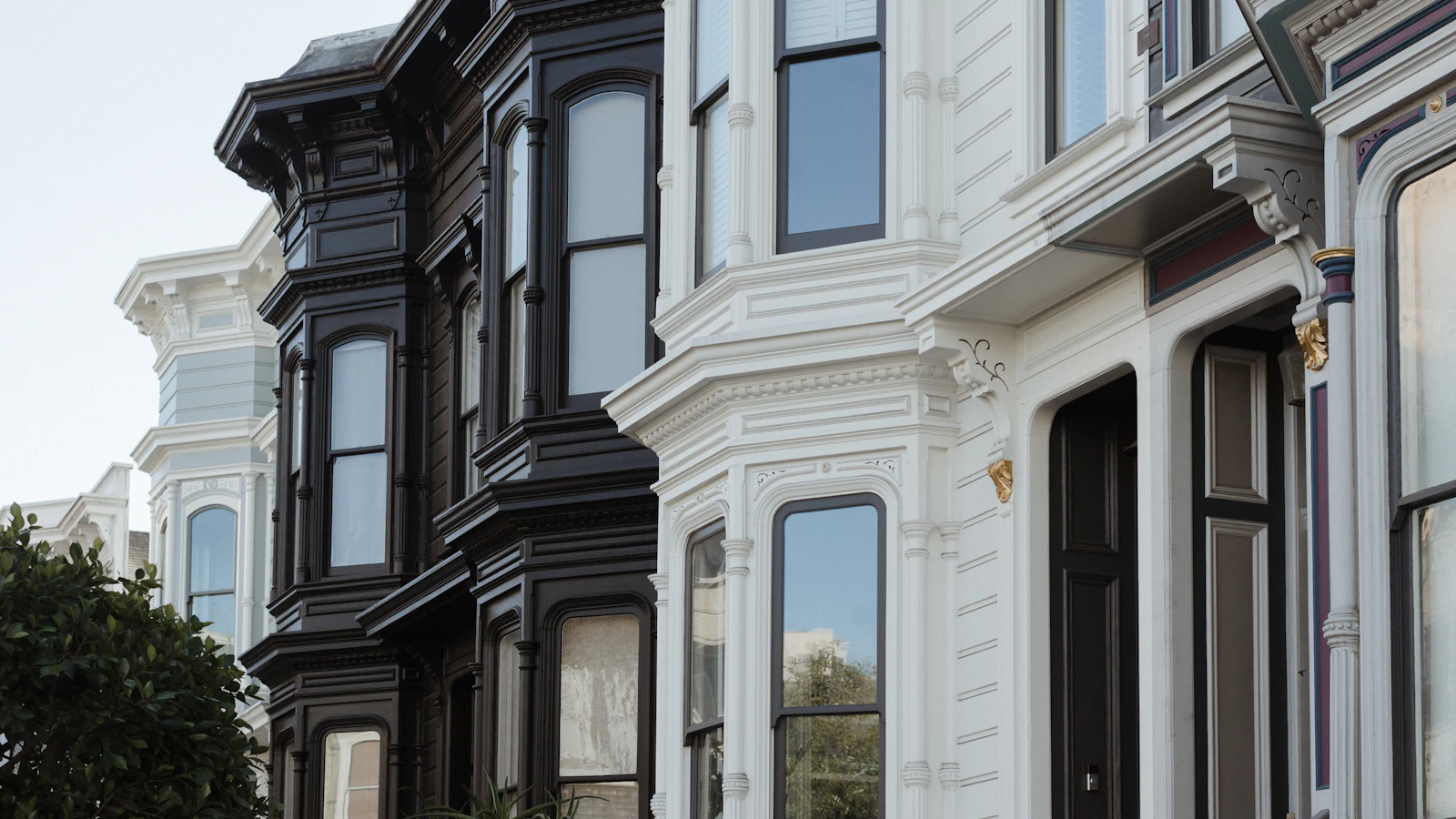 Detailed facades and bay windows on a row of San Francisco Victorian homes.