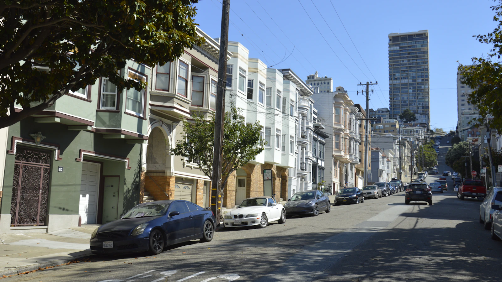 A San Francisco residential street lined with closely connected homes and parked cars.